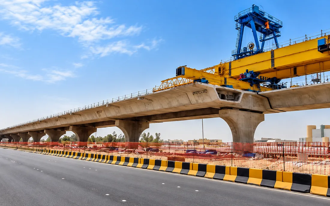 Bridge under construction with a girder launching gantry above the piers