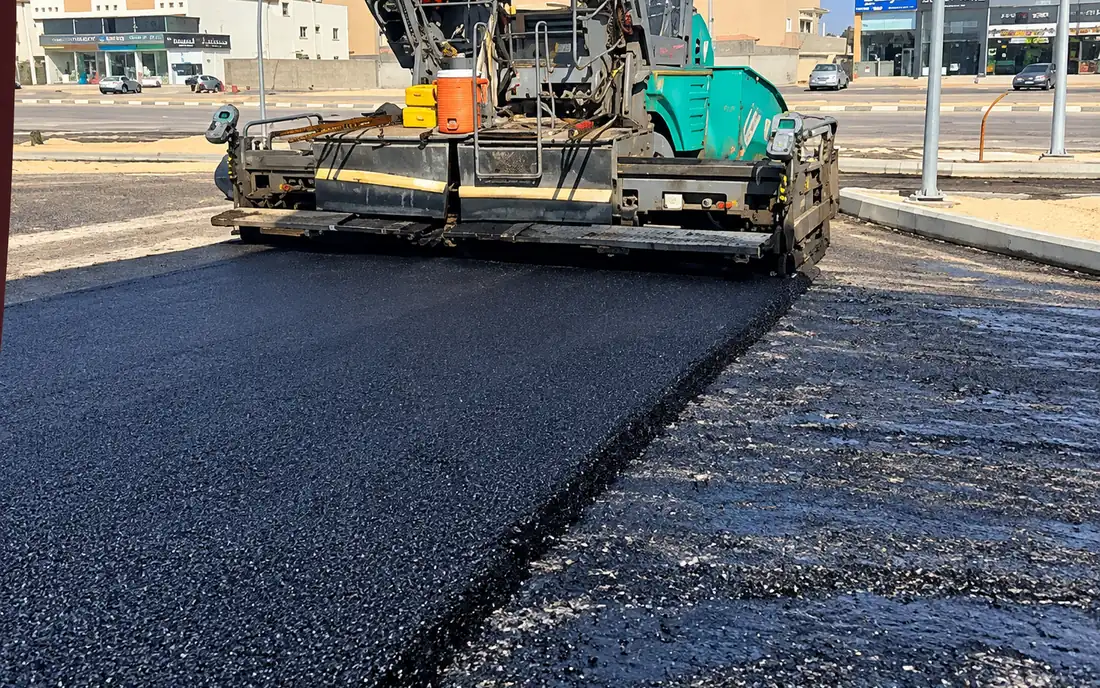 Asphalt paver laying a new course on an existing commercial street