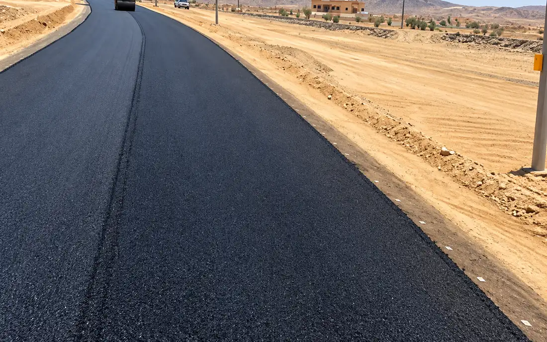 Roller compacting a fresh asphalt mat on a desert road