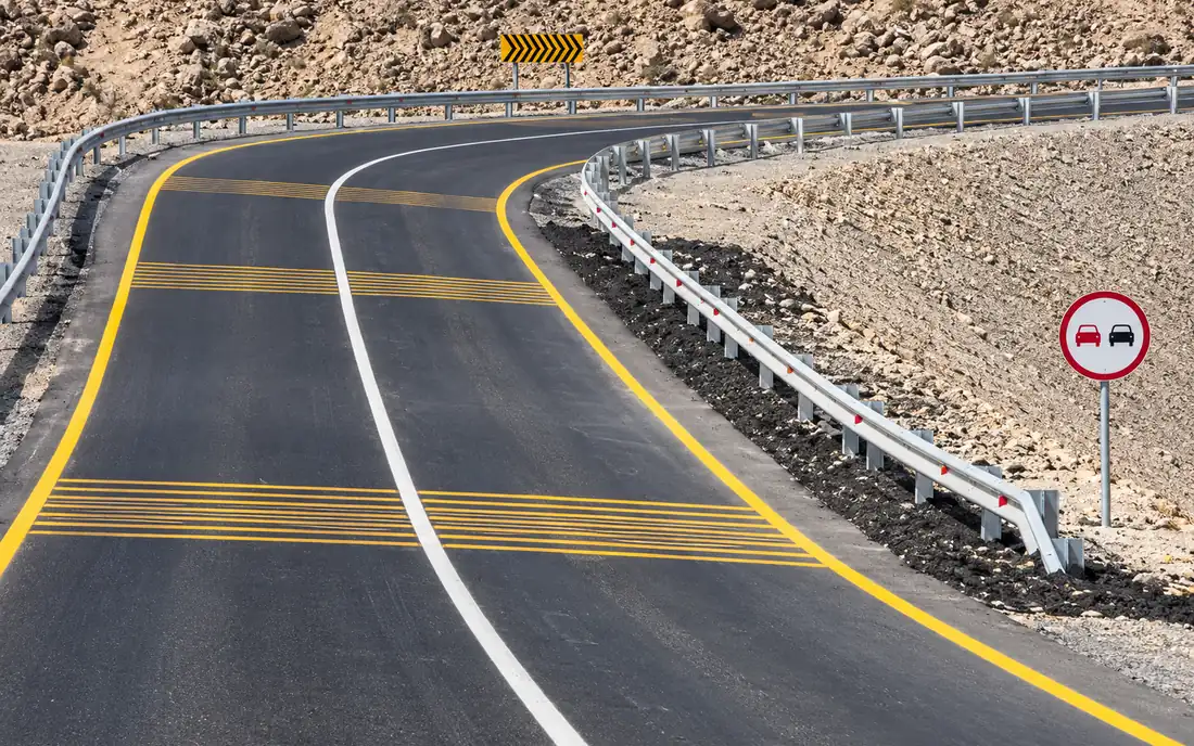 Completed mountain road with guardrails and road markings